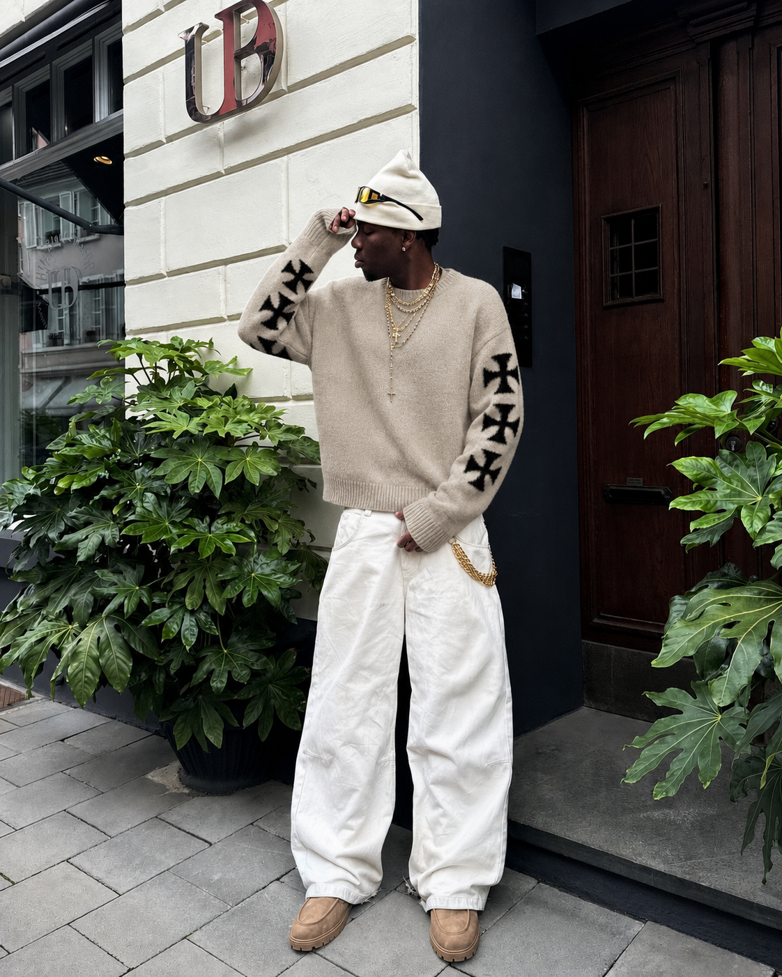 Beige cross sweater worn with white pants Y2K streetwear outfit