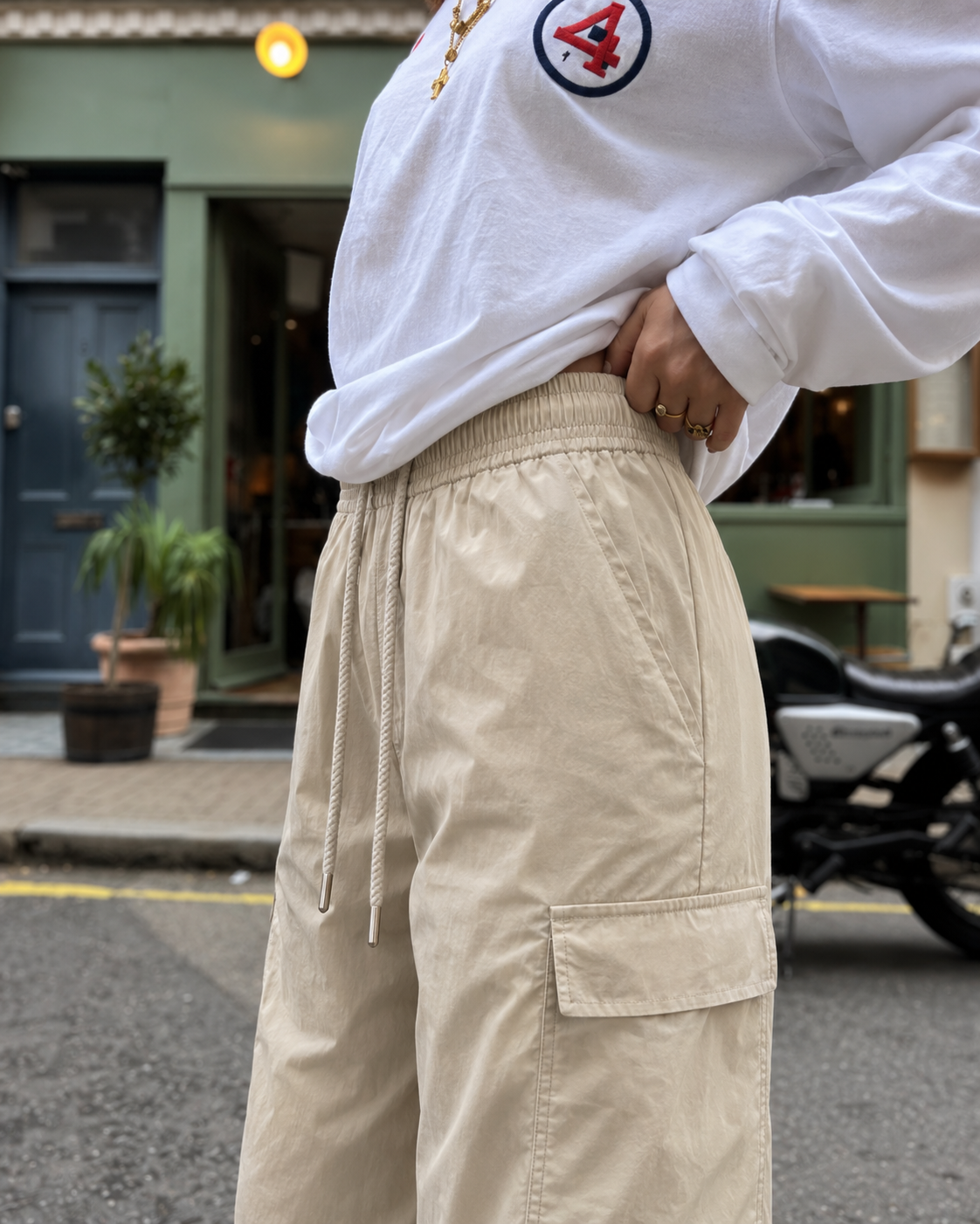 Waistband and cargo pocket detail on beige parachute pants