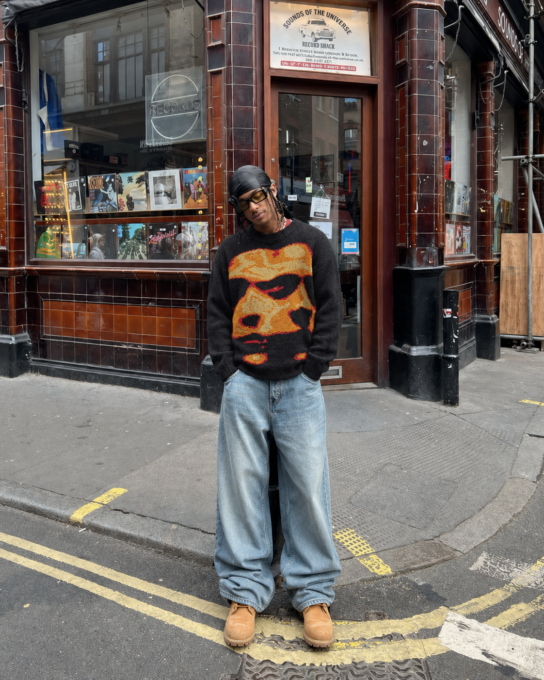 Black graphic sweater worn with baggy jeans in Y2K streetwear style