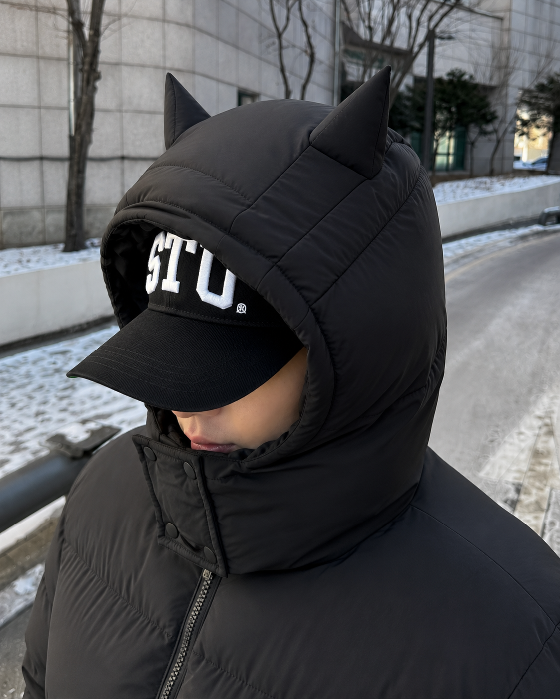 Black puffer jacket pointed hood close-up streetwear detail