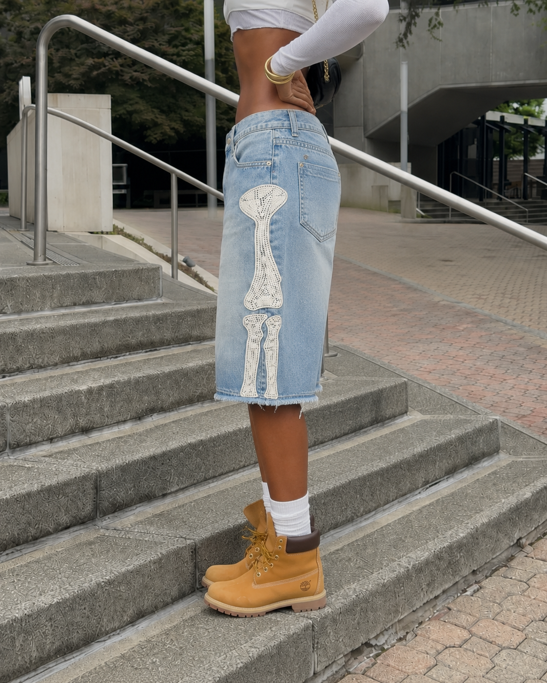 Blue Bone Jorts worn in side view with bone appliqué running along the side