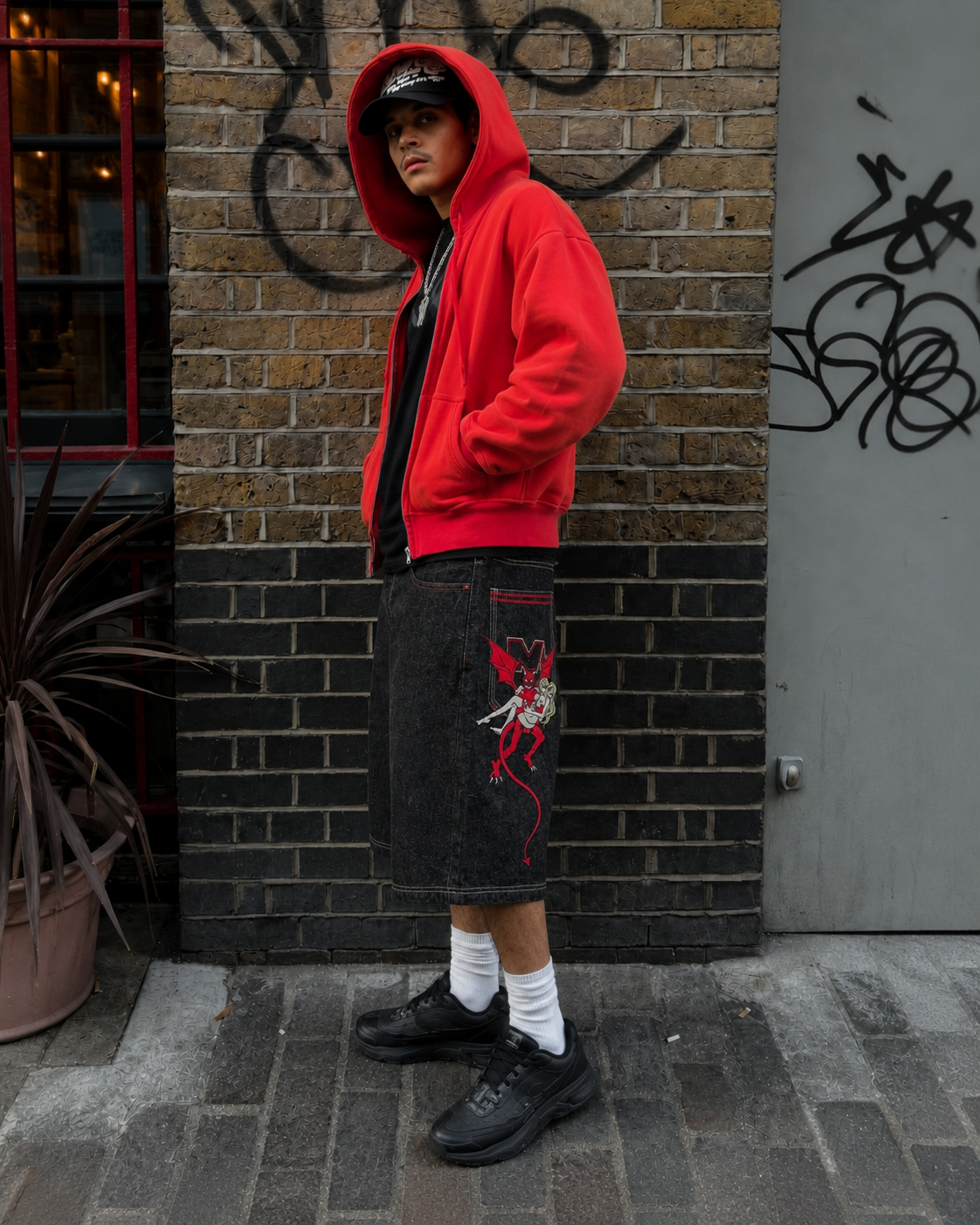 Jorts démon portés de côté, illustration démon rouge sur la jambe visible