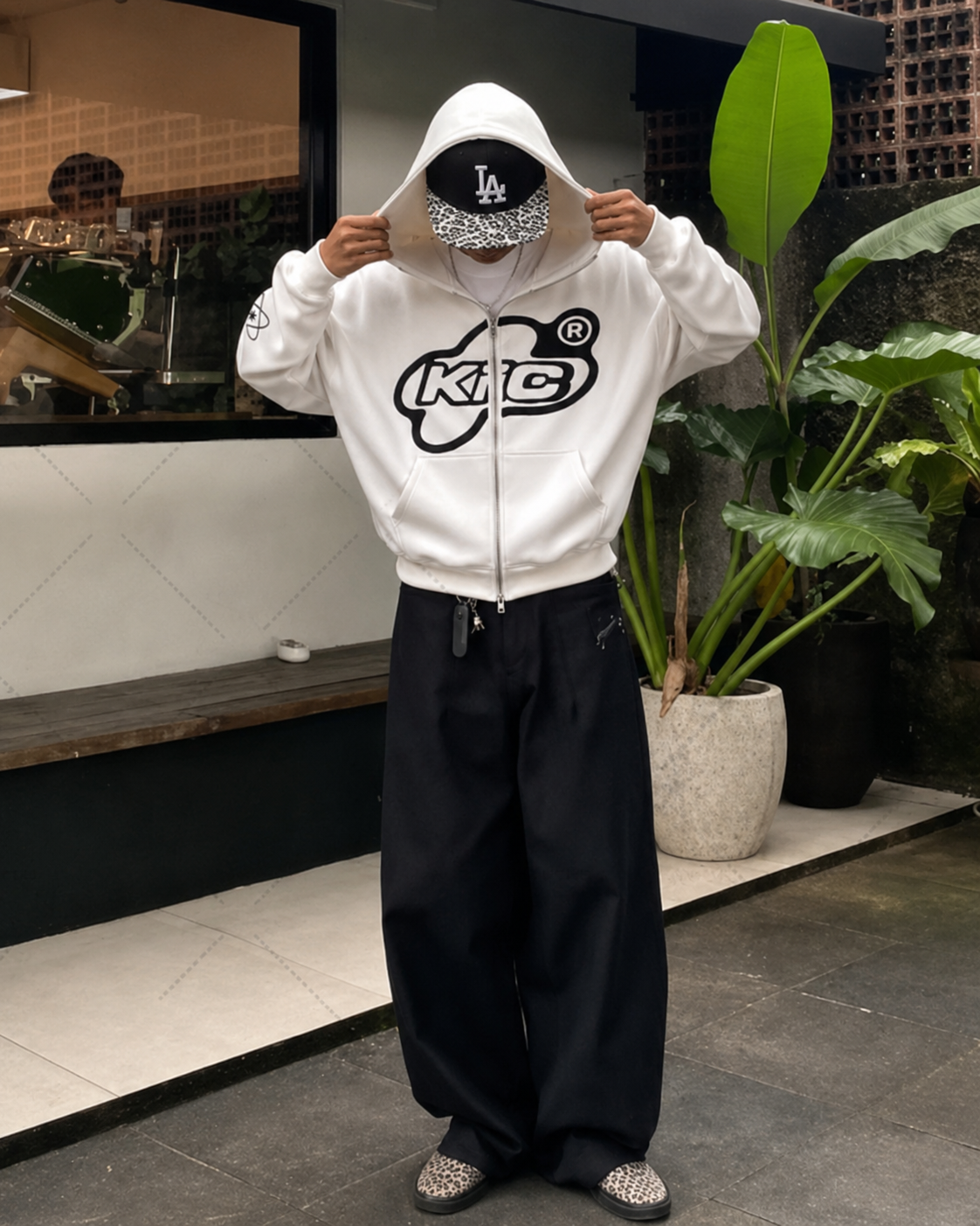 White Y2K full zip hoodie worn outside café with black lettering