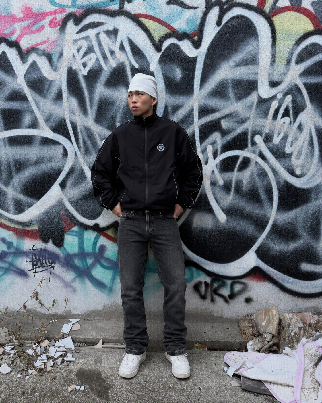 Charcoal Y2K flare jeans worn by graffiti wall