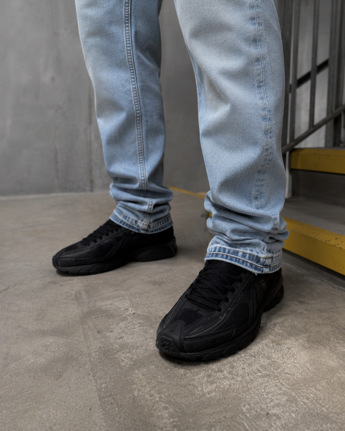 Light blue flare jeans stacked hem over black sneakers