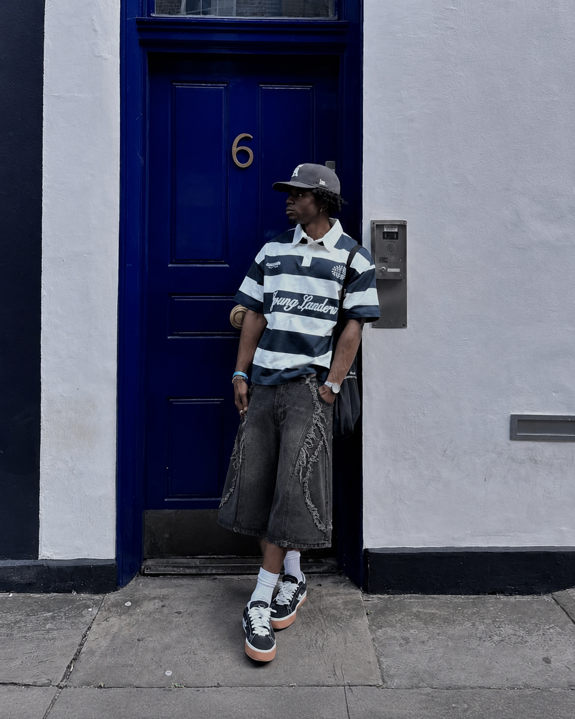 Jorts effilochés noir washed portés en tenue streetwear à Londres