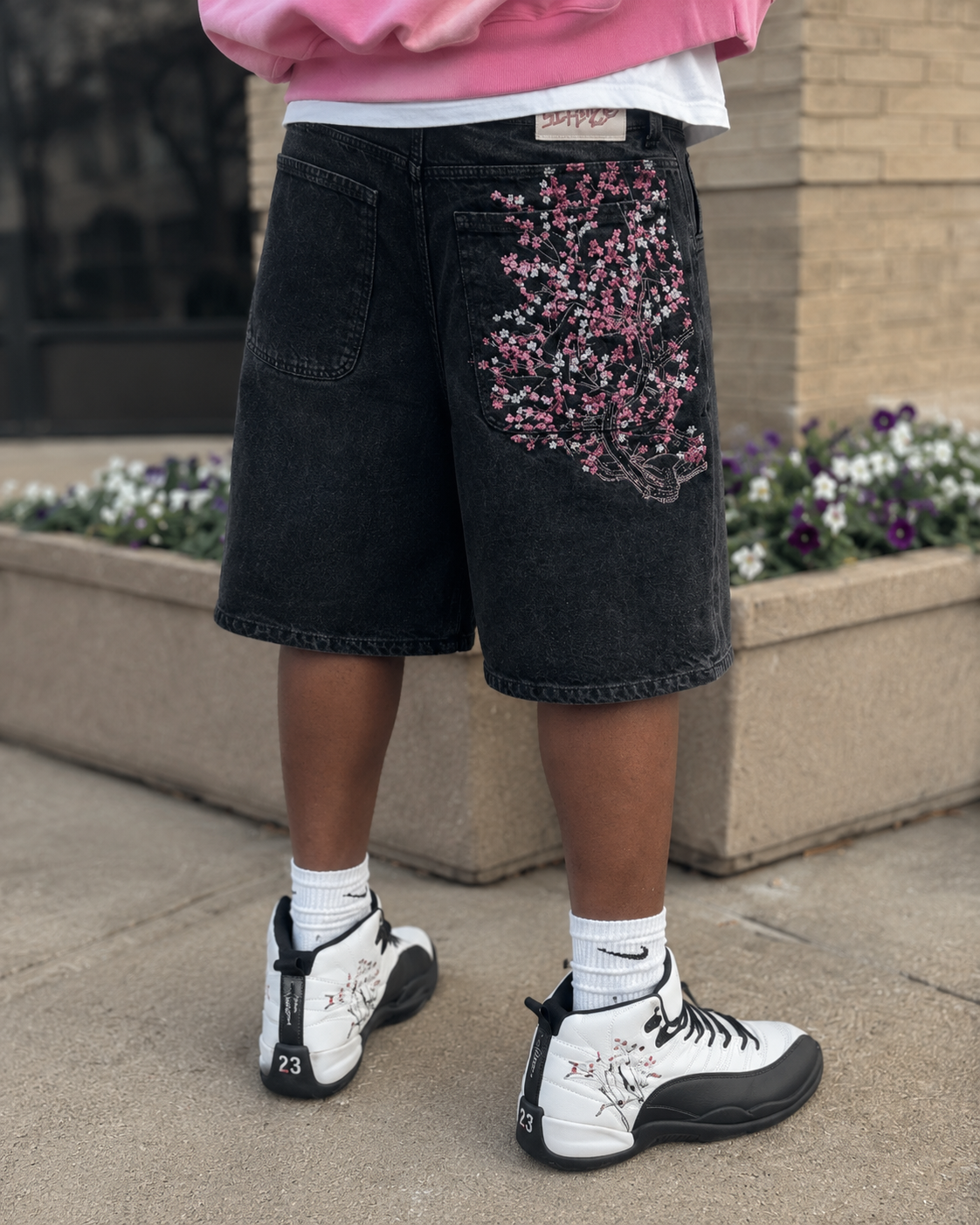 Black sakura jorts close-up while worn with floral embroidery on the back
