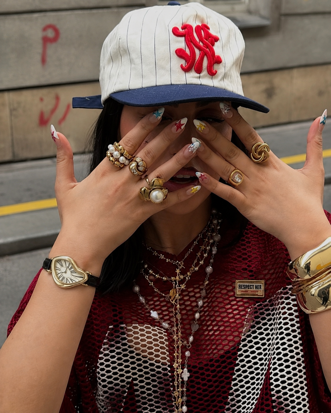 Gold Melting watch worn with Y2K rings and jewellery