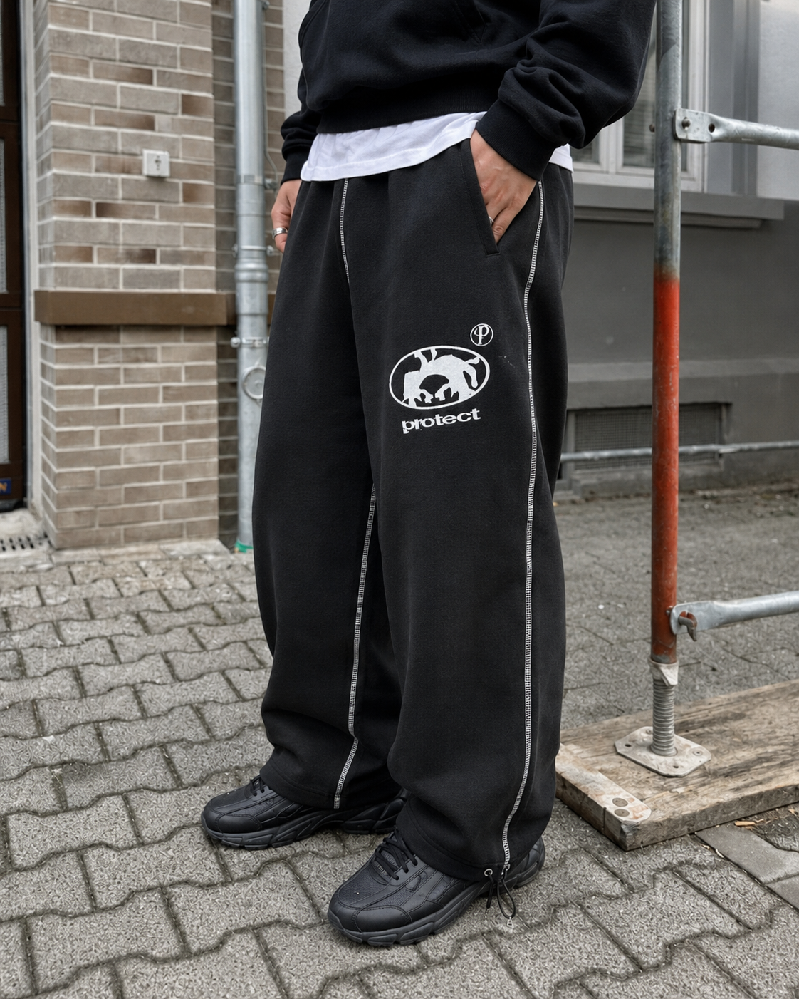 Jogging noir détail logo Protect et surpiqûres blanches