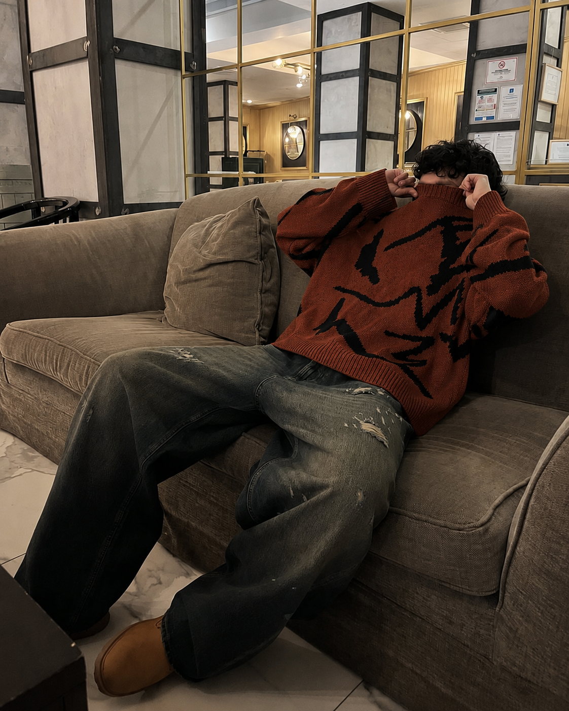 Pull abstrait marron et noir porté assis streetwear