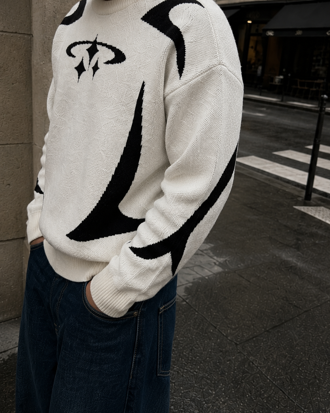 White Y2K sweater sleeve and black motif detail