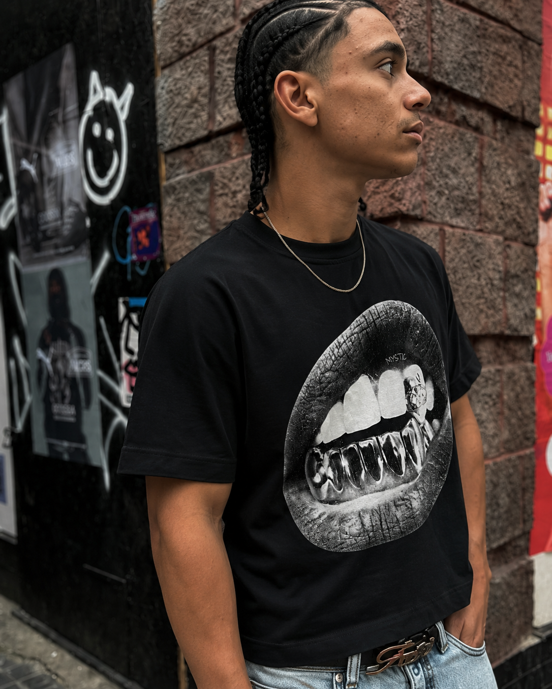 T-shirt graphique Mystic noir porté de côté avec imprimé grillz streetwear