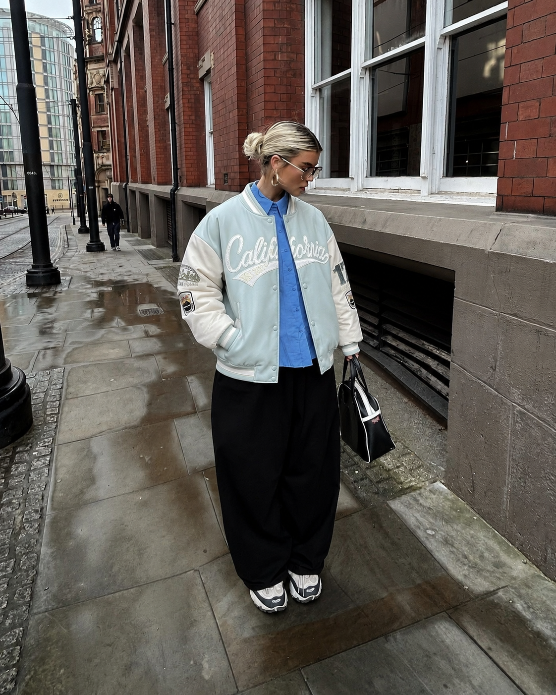 Veste universitaire bleu clair et écrue portée en tenue streetwear