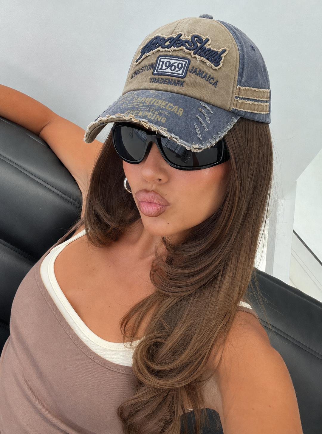 Casquette vintage beige et bleue portée avec lunettes streetwear