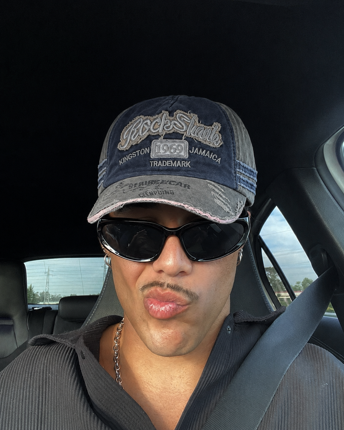 Casquette vintage bleu marine et grise portée avec lunettes en voiture