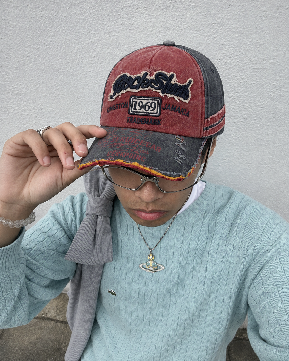 Casquette vintage rouge et grise portée avec pull bleu streetwear