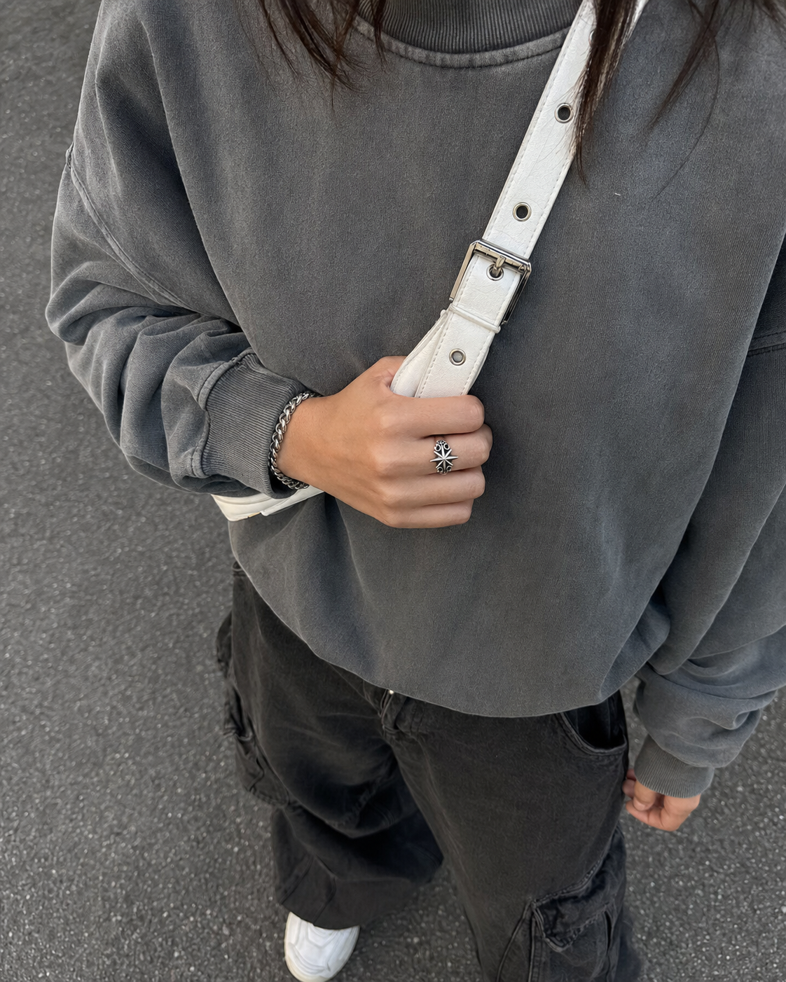 Silver Y2K ring worn with grey streetwear outfit