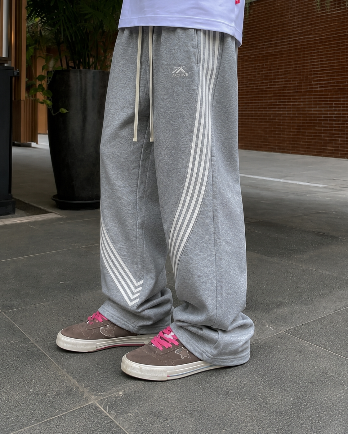 Jogging baggy gris détail bandes courbes et bas empilé