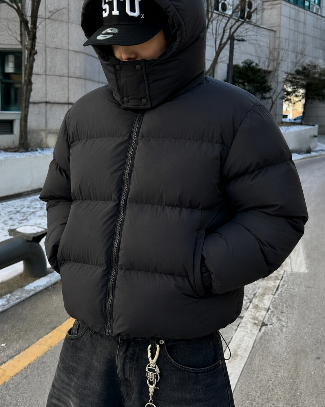 Black puffer jacket high collar zip horn hood front detail