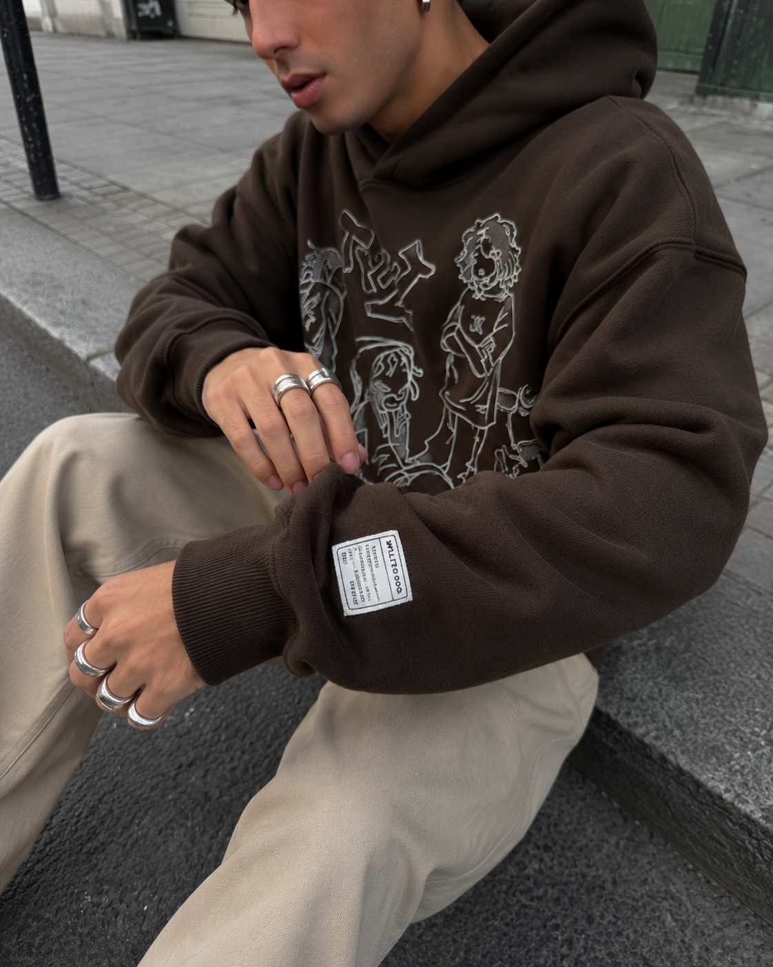 Sleeve label detail on brown cartoon hoodie