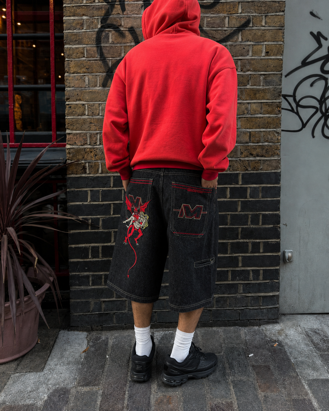 Jorts démon portés de dos, poches arrière avec illustration et broderie M