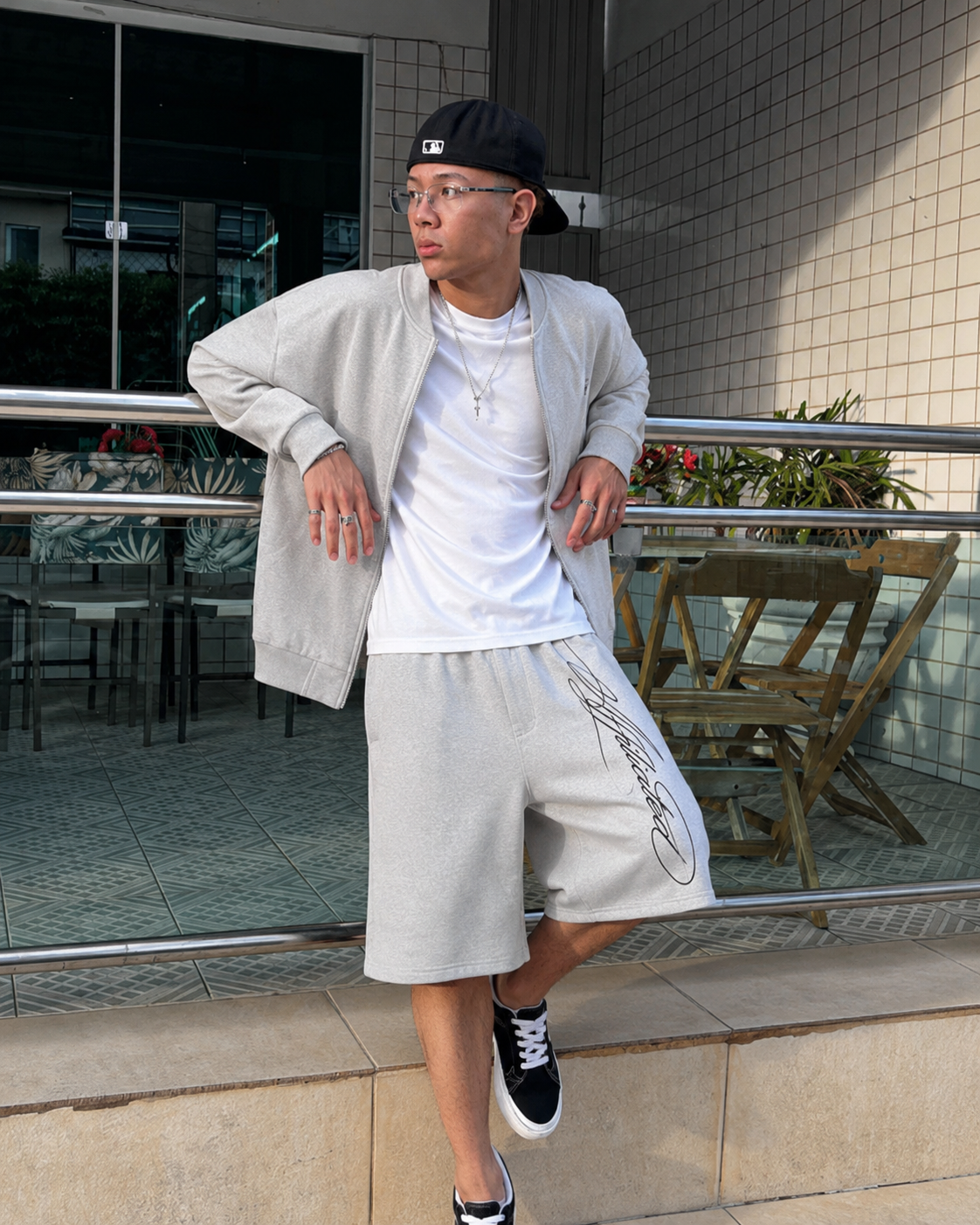 Short baggy gris clair avec signature noire porté dans un outfit streetwear gris