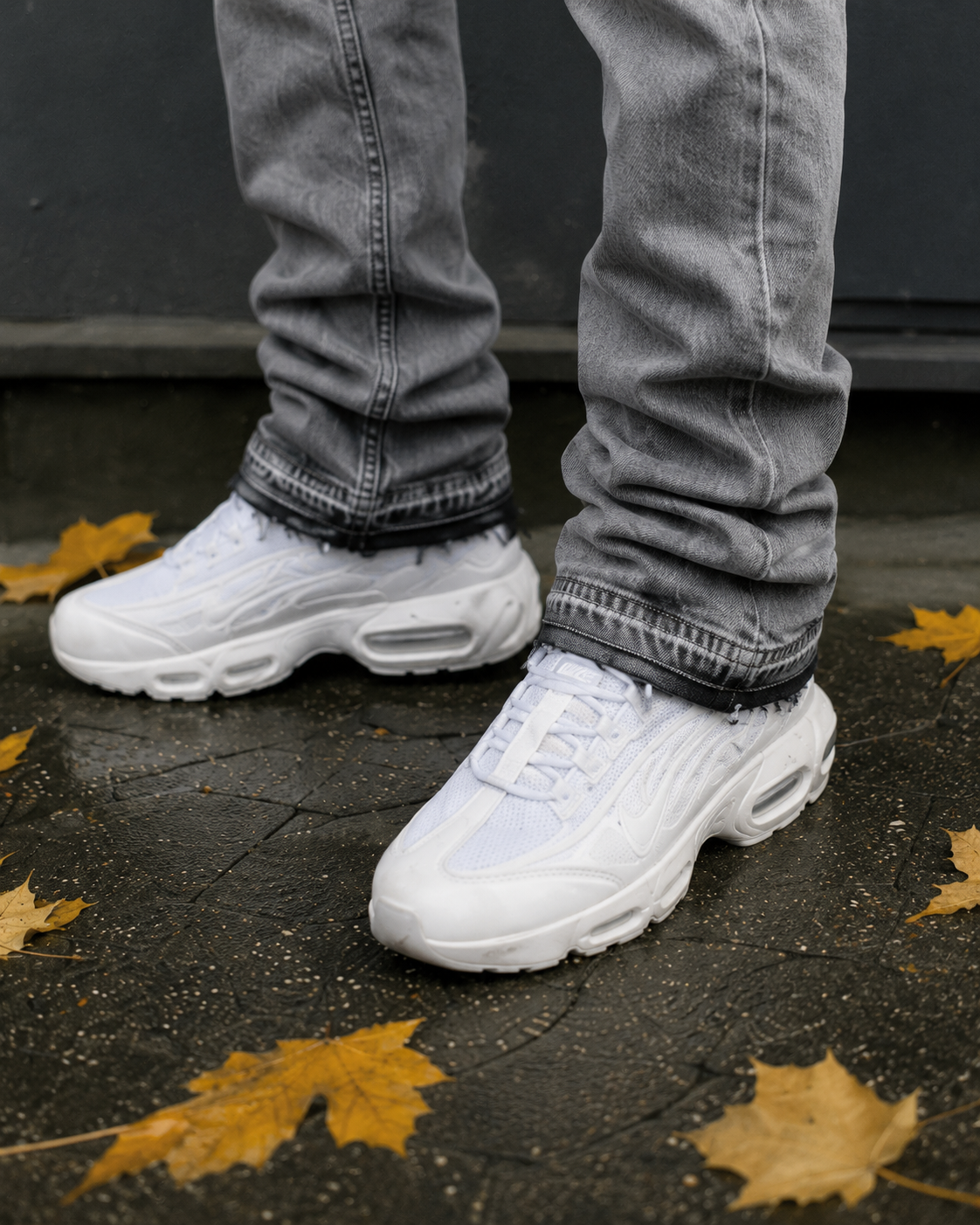 Light grey flare jeans stacked hem over sneakers