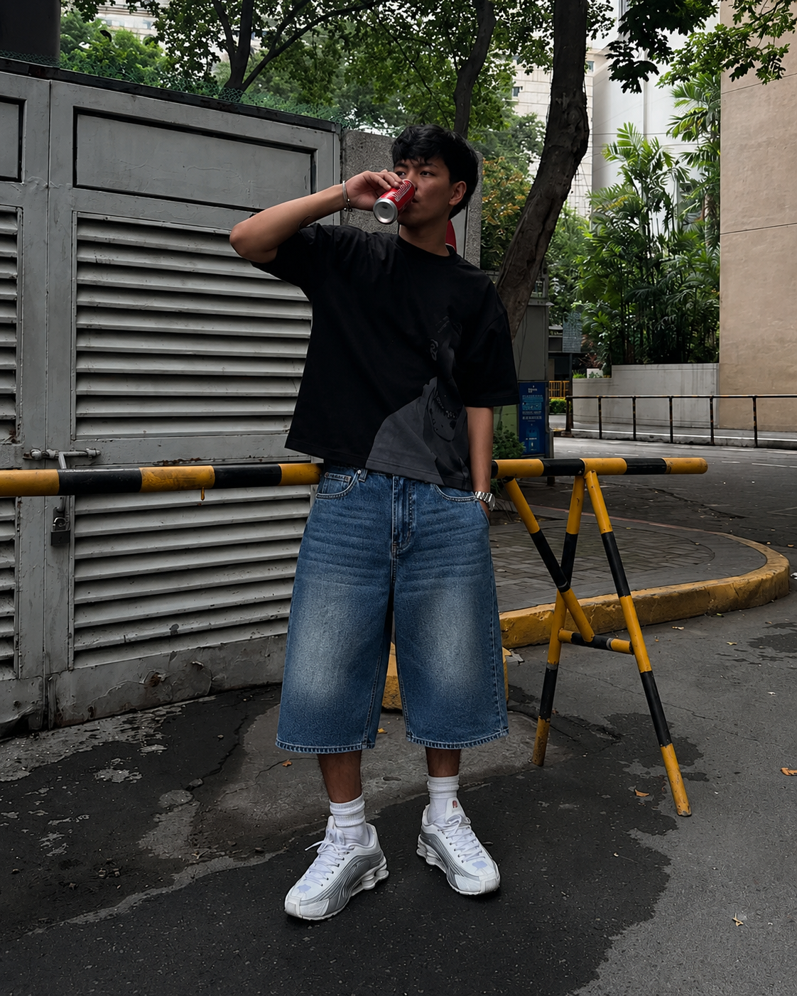 Baggy blue jorts worn with black oversized tee and white sneakers