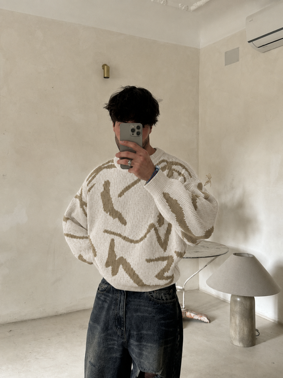Pull abstrait écru et beige porté en miroir