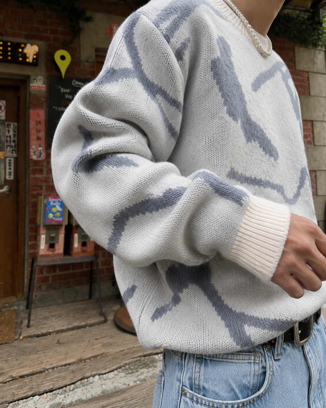 Pull abstrait blanc et bleu gris détail manche en maille