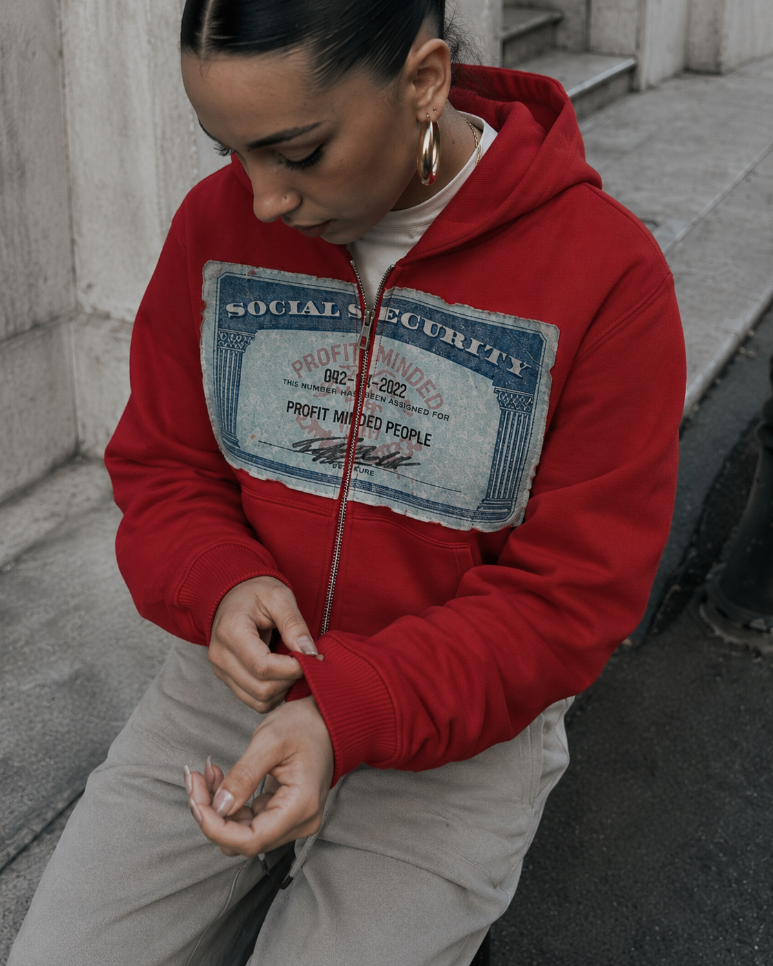 Social Security patch detail on red zip up hoodie