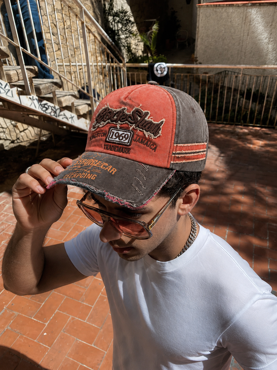 Casquette vintage orange et grise portée streetwear en extérieur