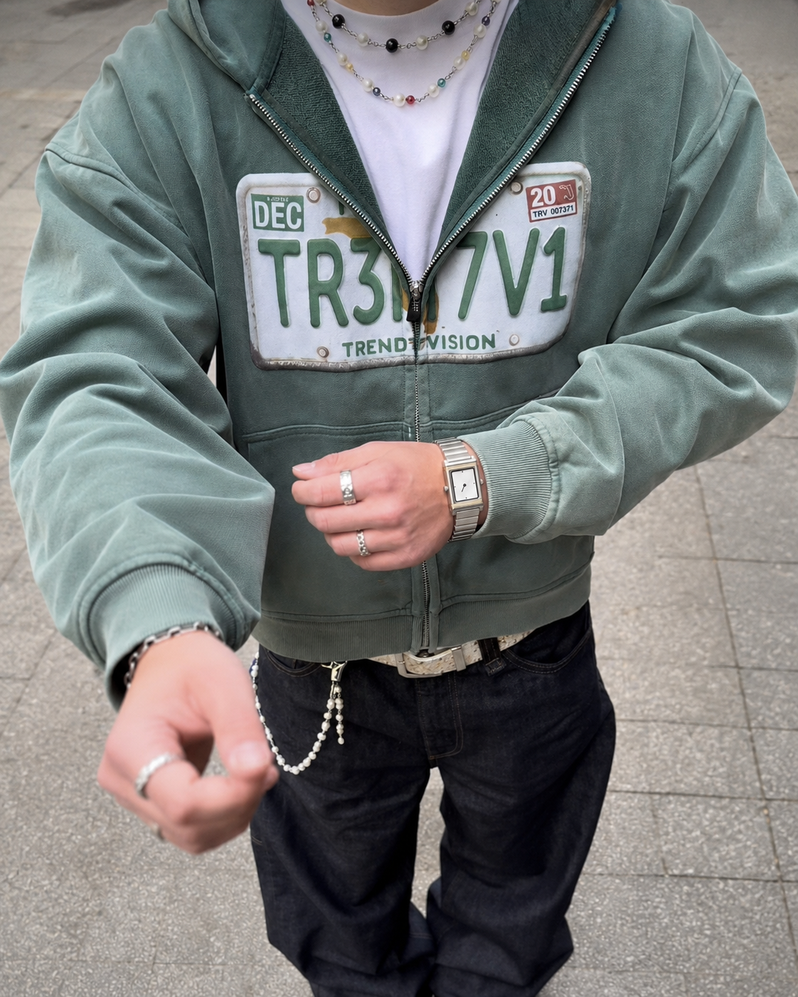 Two-tone rectangular watch worn with green hoodie
